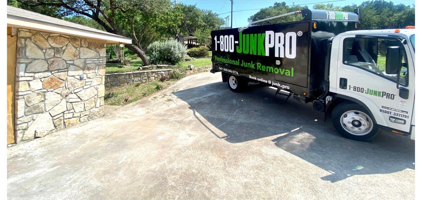 After: the same driveway and stone garage wall clear of debris, the JUNKPRO truck pulling away.