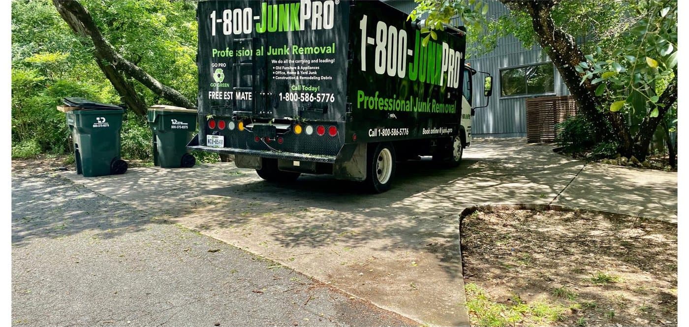 After: the same driveway swept clean down to bare concrete, the JUNKPRO truck parked where the pile used to be.